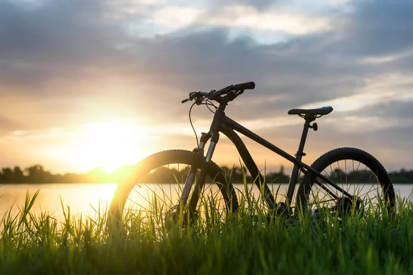 Silhueta Montanha bicicleta por do sol no rio — Fotografia de Stock