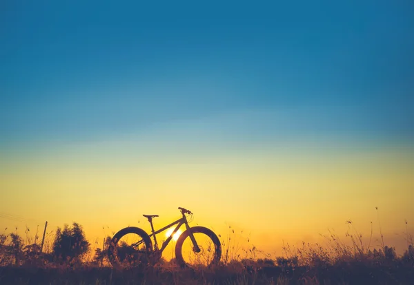 Silhouette snow bike bei schönem Sonnenuntergang, silhouette fatbike — Stockfoto
