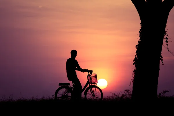 Silhueta solitário homem com bicicleta por do sol — Fotografia de Stock