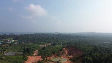 Tropikal kara dönüşümünün hava manzarası yeşil ormanlar, devam eden kazılar, uzak deniz