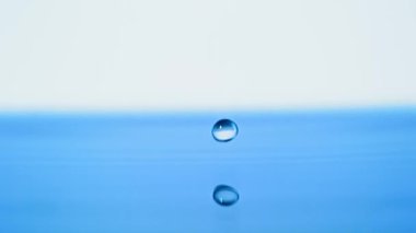 Su damlası yavaş çekimde su yüzeyine düşüyor.