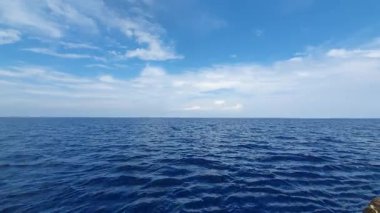 Büyük dalgalı mavi deniz ve bulutlu gökyüzünün arka planında büyük bir bulut.