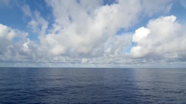 Mavi gökyüzü ve beyaz bulutlarla güzel deniz suyu yüzeyi