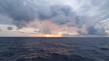 Denizin üzerinde gün batımı. Denizde güzel bir gün batımı. Bulutlu gün batımı.