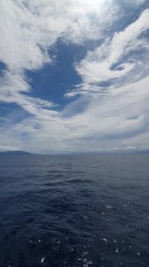 Mavi gökyüzü ve okyanus üzerindeki bulutlar