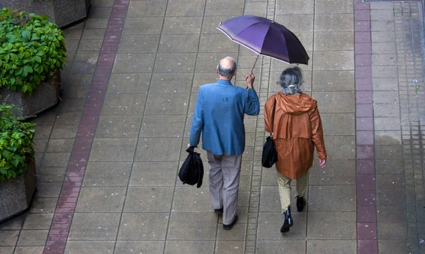 Дощовий день і старший пара під парасолькою — стокове фото