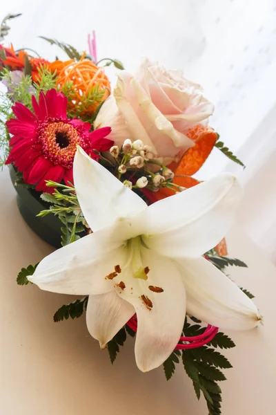 Flowers arrangement with rose and lily in a plastic bowl