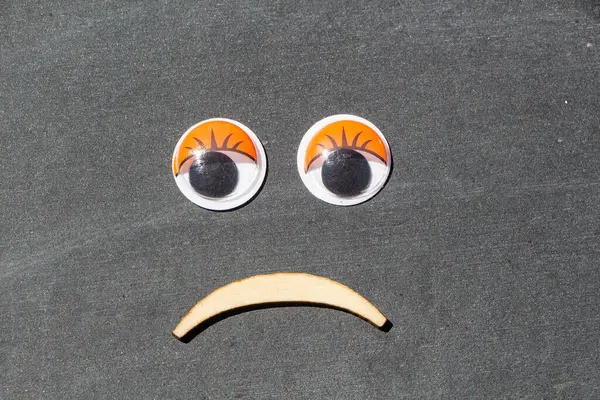 Üzgün Yüz Plastik Gözlerle Gri Arka Planda Tahta Ağızla Yapılmış — Stok fotoğraf