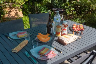 Primelin - Fransa, 21 Ağustos 2019: Beaf Broşetlerle dolu bir bahçede öğle yemeği masası