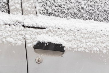 Kışın bir arabanın kapısında kar.