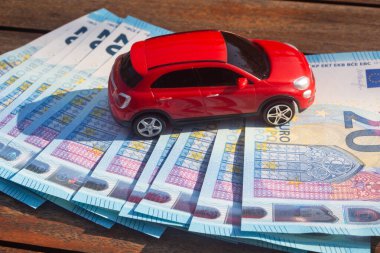 Kırmızı araba ve 20 avroluk banknotlar.