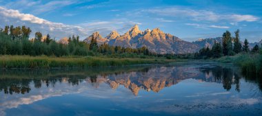 Wyoming Grand Teton Ulusal Parkı 'nda gün doğumunda Ayna Dağları Teton Sıradağları' nın nefes kesici manzarasını sunar. Sakin sular görkemli zirveleri mükemmel bir şekilde yansıtıyor ve şaşırtıcı bir doğal başyapıt yaratıyor..