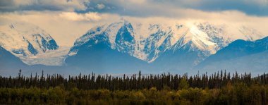 Karlı ve görkemli bir dağ manzarası Denali Ulusal Parkı ve Koruma Alanı, Alaska 'da hakim. 1917 'de kurulan park Alaska Sıradağları' ndaki 6 milyon dönümlük vahşi araziyi koruyor..