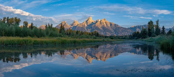 Wyoming Grand Teton Ulusal Parkı 'nda gün doğumunda Ayna Dağları Teton Sıradağları' nın nefes kesici manzarasını sunar. Sakin sular görkemli zirveleri mükemmel bir şekilde yansıtıyor ve şaşırtıcı bir doğal başyapıt yaratıyor..