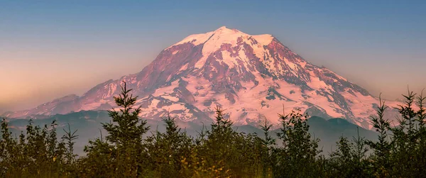 Günbatımı Dağı Majesteleri Rainier Dağı, batan güneşle aydınlatılan karla kaplı zirvesi olan Rainier Dağı Ulusal Parkı 'nda dimdik ayakta duruyor. Dağın görkemli varlığı manzaraya hükmediyor ve nefes kesici bir manzara yaratıyor..