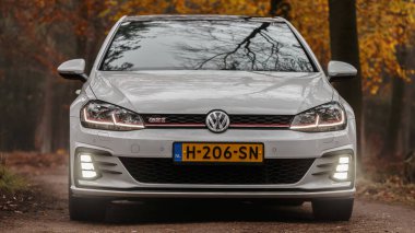 Gündüz vakti güz ormanlarından geçen modern bir araba. 