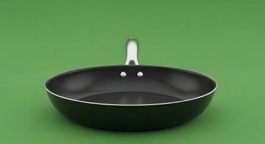 A black frying pan with a silver handle is shown against a solid green background.