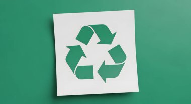 A clean and simple image featuring the universal recycling symbol in green on a white square of paper, set against a solid green backdrop.