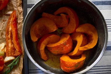 Kabak ve zeytinyağında marine edilmiş balkabağı parçaları biber ve biberiye tepsisinin yanında biber ve biberiyenin yanında, kavrulmaya hazır..