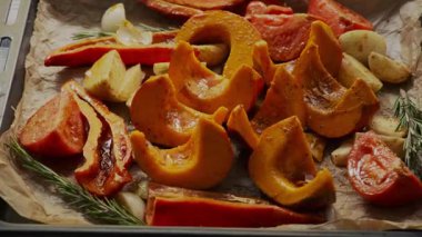 Dilimlenmiş balkabağı, biber, soğan, domates ve biberiye soslu ve baharatlı, kızartılmaya hazır. Taze malzemelerle ev yapımı sonbahar pişirme sahnesi.