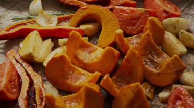 Kızarmadan önce kabak, sarımsak, domates, soğan, biberiye ve zeytin yağı, kırmızı biber ve parşömen kağıdına otların renkli bir karışımı. Doğal ışık, ev yapımı yemek pişirme titreşimleri.