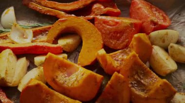 Taze balkabağı, domates, soğan, sarımsak, biber, zeytin yağı, acılı gevrek ve otlarla kaplanmış, pişirmeden önce parşömen kağıdına güzelce yerleştirilmiş. Sıcak sonbahar havası.