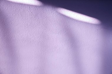 Doğal güneş ışığıyla aydınlatılmış lavanta renkli bir duvar. Yüzeyde soyut desenler oluşturan yumuşak gölgeler. Pastel tonu modern grafik tasarım ve yaratıcı kompozisyonlar için rahatlatıcı bir estetik ideal yaratır..