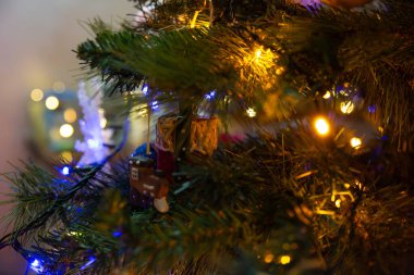 Seçici odaklı ve güzel bokeh efektli her zaman yeşil dalları gösteren bir Noel ağacının sanatsal yakın plan fotoğrafı. Kompozisyonda serin mavi ve sıcak altın iplik ışıkları derinlikte büyülü bir atmosfer arkaplanı oluşturuyor.