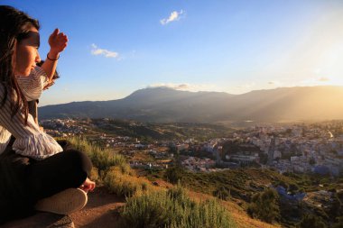 CHEFCHAOUEN, MOROCCO - 29 Mayıs 2017: Meçhul genç kadın, Bouzaafer Camii 'nden (İspanyolca olarak bilinir) Chefchaouen' in panoramasına bakın. Kasabanın en iyi manzarası bu..