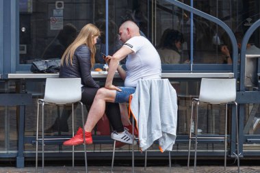 BERGAMO, İTALYA - 22 Mayıs 2019: Meçhul erkek ve kadın Bergamo 'da bir açık kafede masalarda oturuyorlar ve birbirlerine dikkat etmiyorlar.