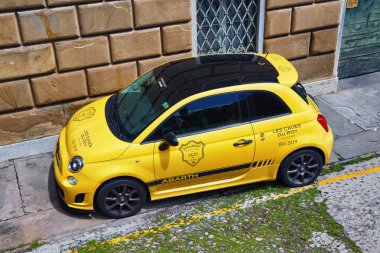 BERGAMO, İtalya - 22 Mayıs 2019: Abarth 500 sarı araba sokakta. Abarth bir İtalyan yarış arabası ve yol arabasıdır. Abarth, FCA İtalya 'nın (eski adıyla Fiat Group Otomobilleri) tam teşekküllü bir yan kuruluşudur.).