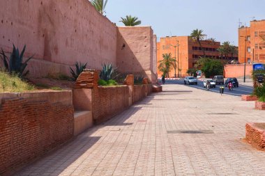 MARRAKESH, MOROCCO - HAZİRAN 03, 2017: Güneşli bir günde Marakeş 'teki eski tarihi bir bölgenin etrafındaki kırmızı ortaçağ duvarlarının bir kısmı. 