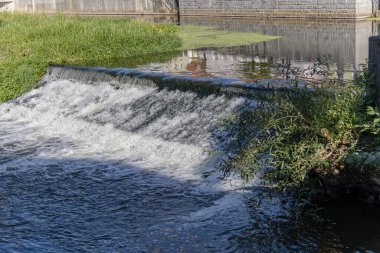Şelale gibi suyu olan küçük güzel bir baraj, eski bir hidroelektrik tesisatının parçası. Yenilenebilir enerji kavramı, doğa ve hareket.