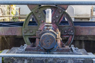 Tarihi bir hidroelektrik güç sisteminden kalma eski bir türbin motoru, pas ve yaş belirtileri gösteriyor. Yenilenebilir enerji, mühendislik ve klasik teknolojiyi temsil eden endüstriyel makineler konsepti.