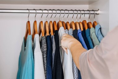 Gömlek ve kazaklarla dolu temiz bir dolap.