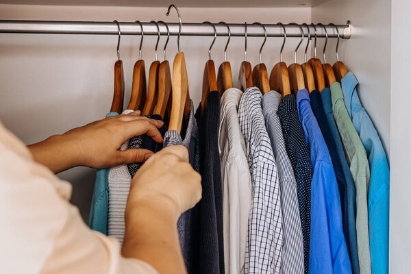 Сортировка рубашек на деревянных вешалках