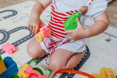 Bebeklerin renkli plastik blokları olan bir kule inşa edişinin yakın görüntüsü. Yaratıcılık kavramı, problem çözme ve erken çocukluk gelişimi.