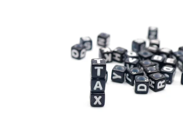 Kara Küpler Kelime Vergisini Gösteriyor. Kara alfabe bloklarının vergilerin minimalist fotoğrafı. Gelir vergisi, iş düzenlemesi ve mali yönetimle ilgili yayın içeriği için harika