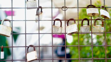 Çitlerdeki paslı asma kilitlerin ayrıntıları, endüstriyel dokuları ve kısıtlama ve güvenlik temaları vurgulanıyor