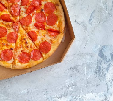 Beton arka planda sosis peynirli pizza.