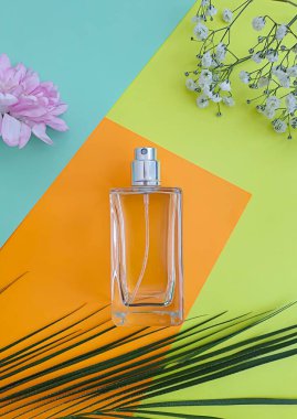 Renkli arka planda bir şişe parfümü çiçeği.