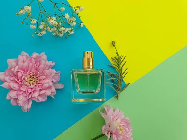 Renkli arka planda bir şişe parfümü çiçeği.