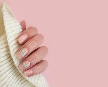 Kadın eli, zarif manikür süveter.