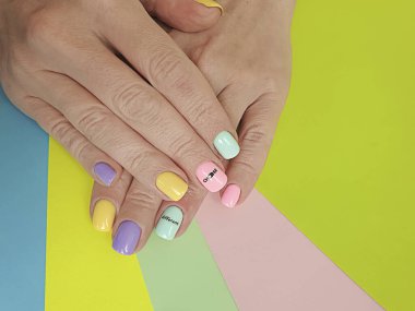 Kadın eli. Renkli arka planda güzel bir manikür.