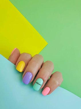 Kadın eli. Renkli arka planda güzel bir manikür.