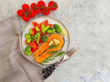 Tabakta kızarmış somon dilimi, çimentoda domates.