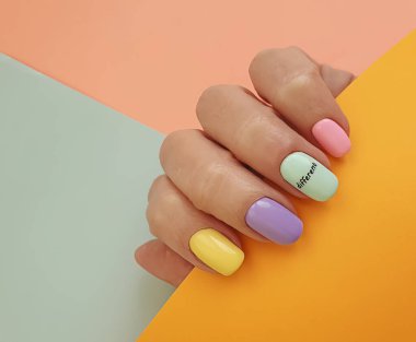 Kadın eli. Renkli arka planda güzel bir manikür.