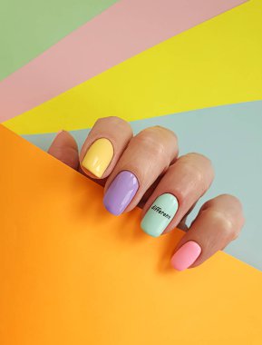 Kadın eli. Renkli arka planda güzel bir manikür.