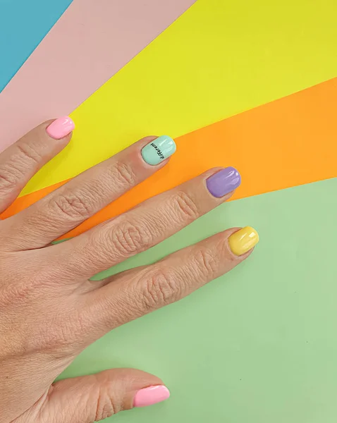 색깔있는 배경에 아름다운 매니큐어를 손으로 — 스톡 사진