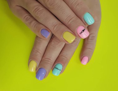 Kadın eli. Renkli arka planda güzel bir manikür.